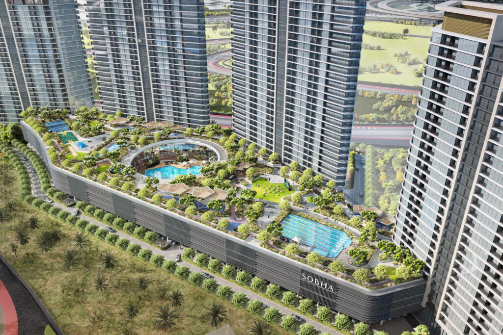 Aerial view of towers around a landscaped podium with pools at Sobha Solis, Motor City, Dubai