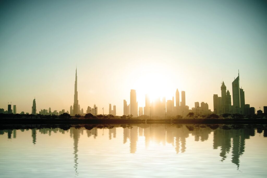 Downtown Dubai skyline at sunrise reflected in the water near Opera Grand