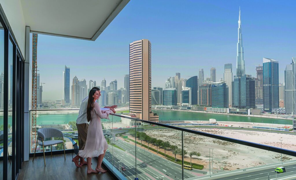 Resident on a balcony with Burj Khalifa view at SOL Bay, Business Bay