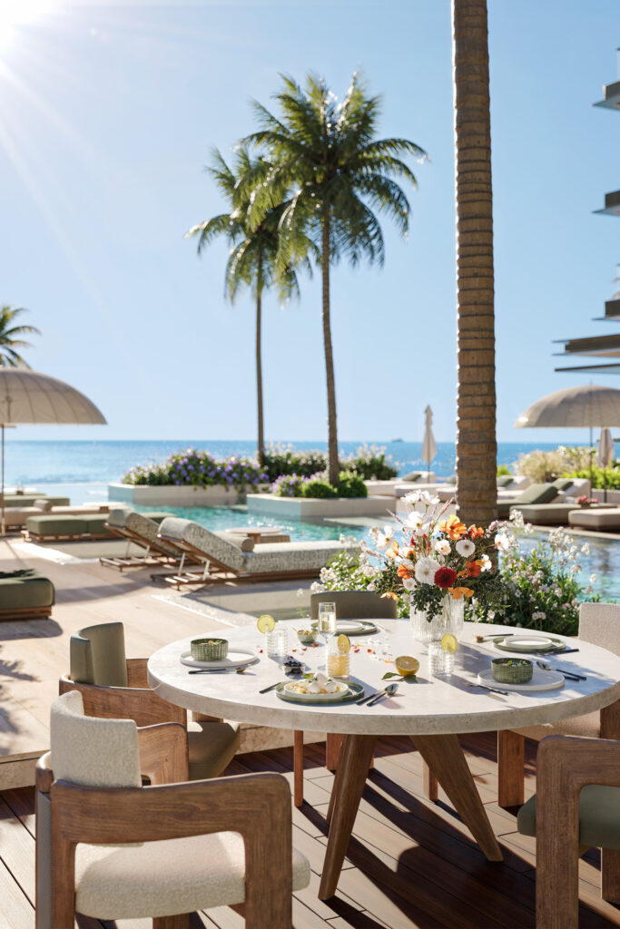 Poolside dining table under palms at Cheval Residences