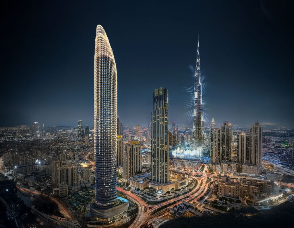Slender tower lit at night alongside Burj Khalifa and the Downtown skyline at Binghatti Skyblade, Downtown Dubai