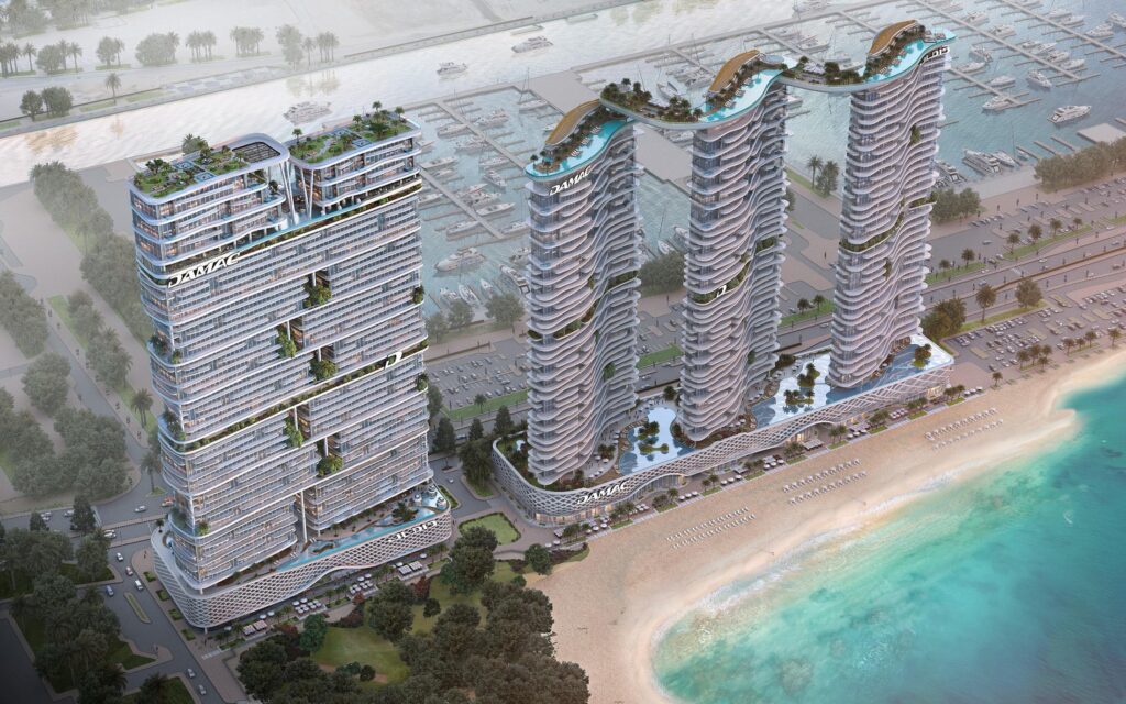 Aerial view of the towers above a sandy beach and turquoise sea at DAMAC Bay 2, Dubai Harbour