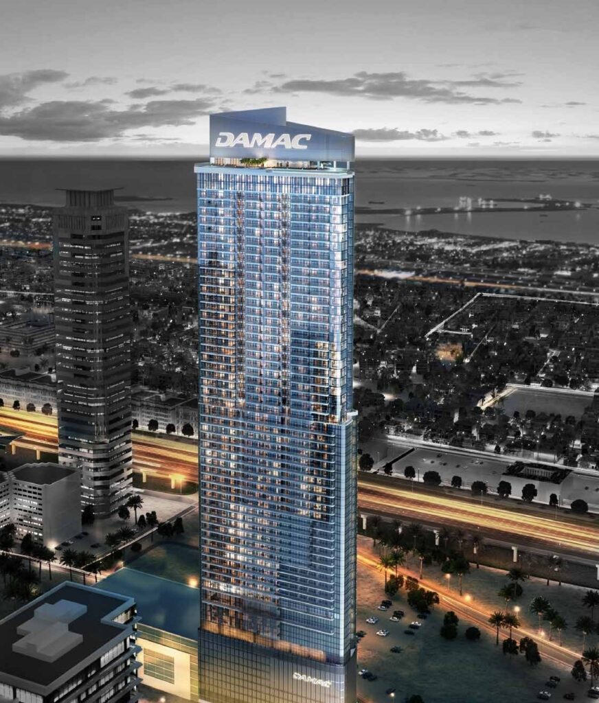 DAMAC Towers by Paramount tower lit at night above the city, Business Bay