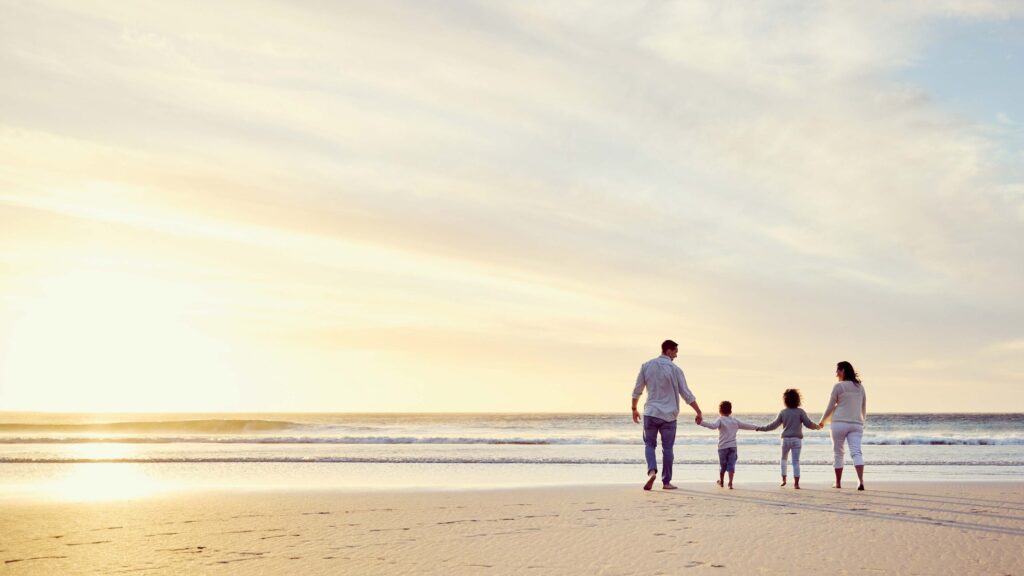Family walking on the beach at sunset near Flora Shore, Dubai Islands