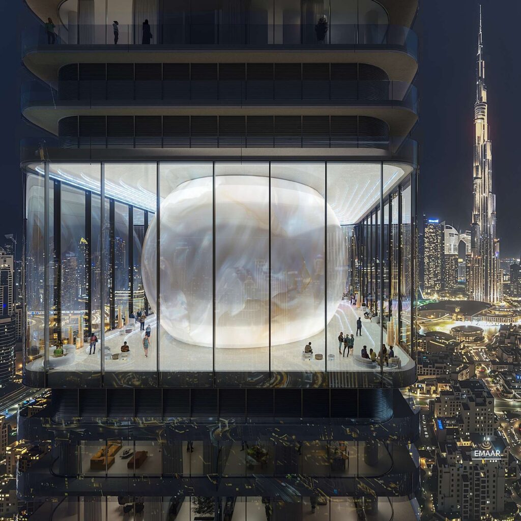 Illuminated moon atrium with the Burj Khalifa beyond at Inaura Hotels and Residences