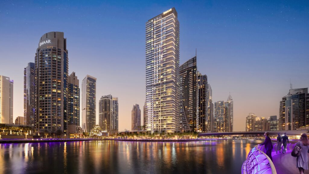 Residential tower rising among marina towers at night by the waterfront at Marina Shores, Dubai Marina