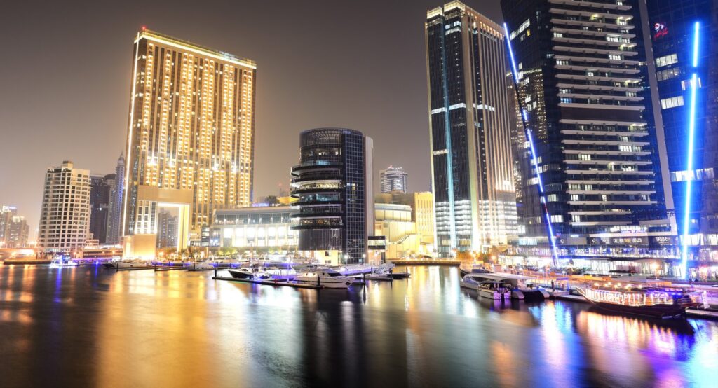 Illuminated marina towers reflected on the water at night near Marina Shores, Dubai Marina