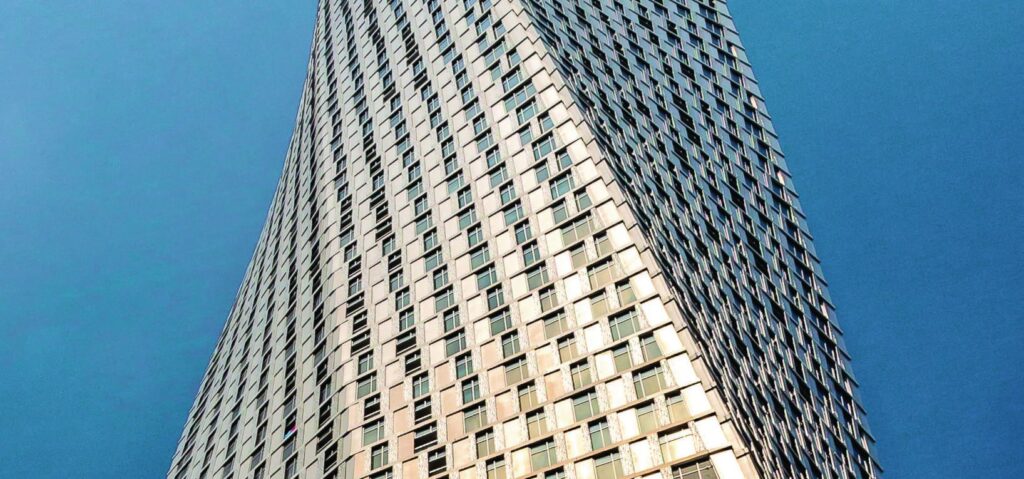 Textured facade of Natuzzi Harmony Residences rising against a blue sky, Dubai Islands