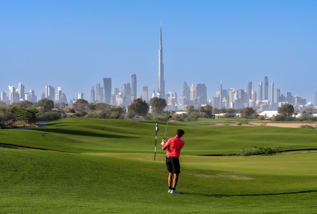 Golfer on the Dubai Hills course with the Burj Khalifa beyond, near Palace Residences Hillside