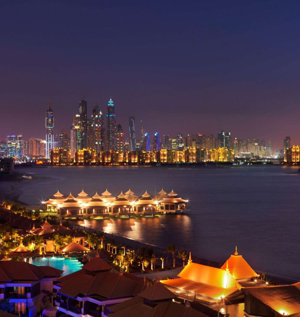 The Anantara Residences at night with the Dubai Marina skyline across the water, Palm Jumeirah