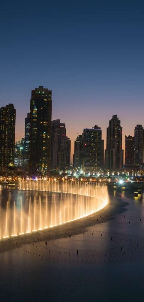 Dubai Fountain and Downtown towers at night near Velor
