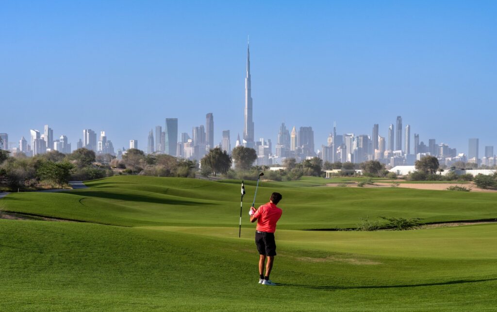 Golfer on the Dubai Hills course with the Burj Khalifa beyond, near Vida Residences Hillside